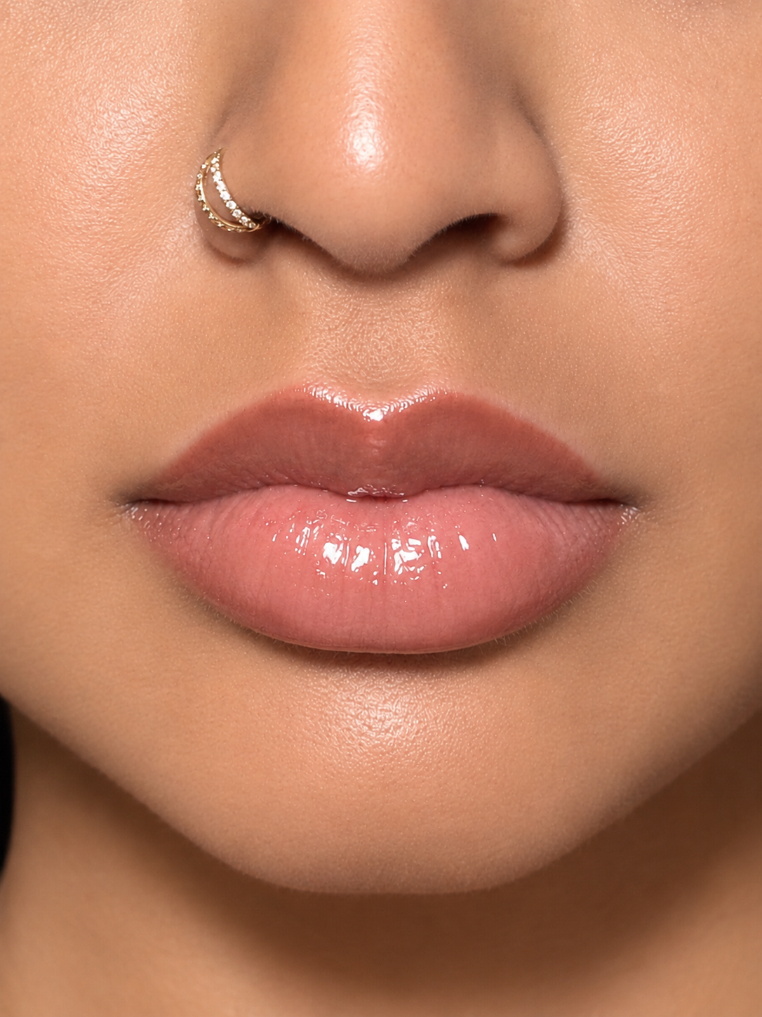 Close-up of glossy rose-brown lips with natural lip colour visible
