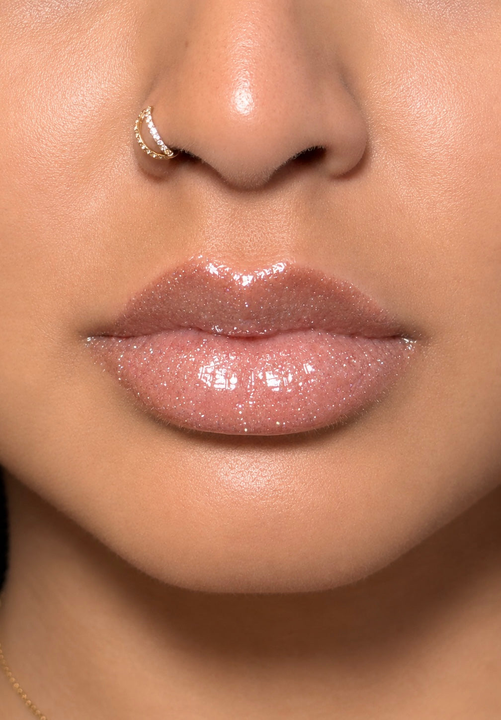 Green and Jaded clear shimmer gloss on lips in bright direct light